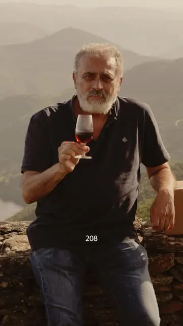 Um homem a provar vinho do Porto sobre o Douro